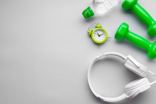 Hanteln, Wasserflasche, Kopfhörer und Timer als Vorbereitung für ein Workout.